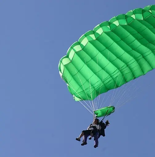 a person is parasailing in the air with a parachute