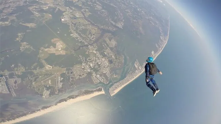 a man flying through the air on top of a parachute