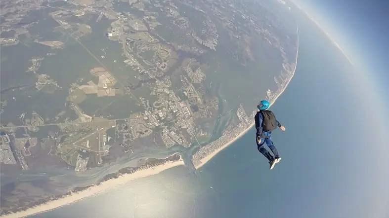 a man flying through the air on top of a parachute