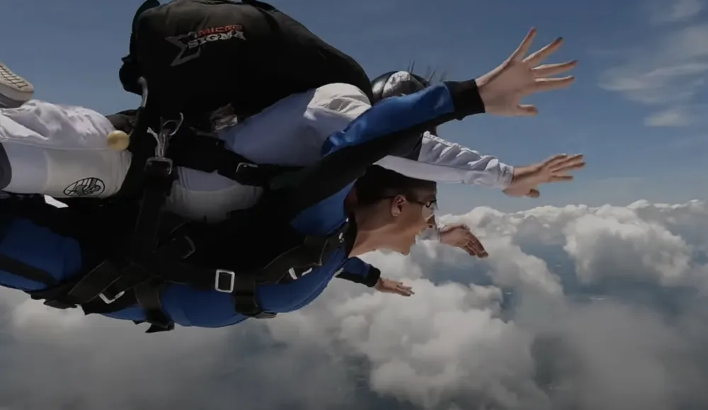 a man in a skydiver is in the air above the clouds